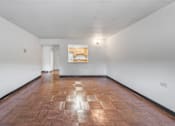 Thumbnail 25 of 25 - a living room with white walls and a wooden floor and a window
