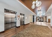 Thumbnail 5 of 25 - a lobby with elevators and a carpeted floor and stainless steel doors