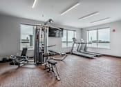 Thumbnail 20 of 25 - a gym with treadmills and other exercise equipment and windows