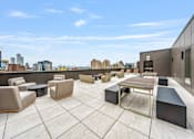 Thumbnail 25 of 25 - a rooftop patio with chairs and tables and a view of the city