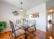 Thumbnail 8 of 23 - a dining room with a glass table and chairs