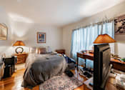 Thumbnail 12 of 23 - a bedroom with a bed and a tv