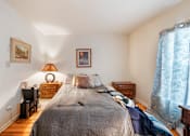 Thumbnail 11 of 23 - a bedroom with a bed and two dressers and a window