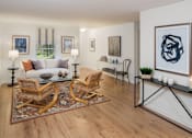 Thumbnail 3 of 19 - Furnished living room with a white couch and two wicker chairs sitting on top of an area rug