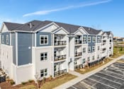 Thumbnail 42 of 44 - an image of an apartment building with a parking lot