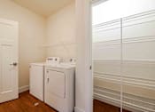 Thumbnail 20 of 49 - A white laundry room with a washer and dryer.