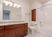 Thumbnail 46 of 49 - A bathroom with a white tub, sink, and toilet.