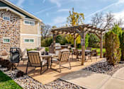 Thumbnail 26 of 49 - A patio with a table and chairs under a pergola.