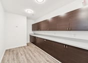 Thumbnail 22 of 230 - A room with brown and white cabinets and a light brown floor.