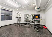 Thumbnail 127 of 230 - A gym with a treadmill, exercise bike, and other equipment.