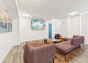 Thumbnail 7 of 230 - A room with a painting on the wall and a couch.