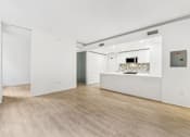 Thumbnail 33 of 230 - A white room with a wooden floor and a white counter.