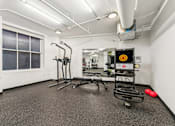 Thumbnail 47 of 230 - A gym with a treadmill, exercise bike, and other equipment.