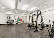 Thumbnail 46 of 230 - A gym with a variety of equipment including weights and exercise machines.
