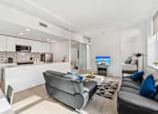 Thumbnail 57 of 230 - A modern living room with a grey sofa and a television.