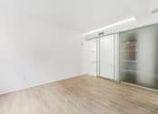 Thumbnail 59 of 230 - A room with a sliding glass door and wood flooring.