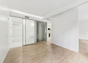 Thumbnail 54 of 230 - A room with a white wall and a wooden floor.