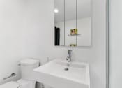Thumbnail 102 of 230 - A white sink in a bathroom with a mirror above it.