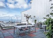Thumbnail 6 of 12 - a patio with a table and chairs and a view of the ocean