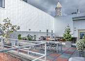 Thumbnail 5 of 12 - the patio of the building has tables and chairs and a grill