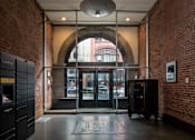 Thumbnail 2 of 12 - a lobby with an arched door and a brick building in the background