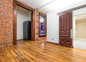 Thumbnail 10 of 12 - a living room with a wooden door and a door to a closet