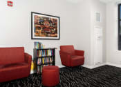 Thumbnail 29 of 45 - a room with three red chairs and a bookshelf filled with books