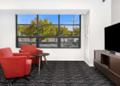 Thumbnail 27 of 45 - a living room with chairs and a television