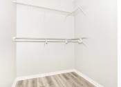 Thumbnail 15 of 45 - an empty closet with white walls and wood flooring and a white walled closet