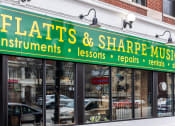 Thumbnail 41 of 45 - a storefront with a green sign that reads floats  shape music instruments lessons and repairs