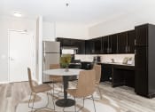 Thumbnail 9 of 45 - a kitchen and dining area with black cabinets and a refrigerator