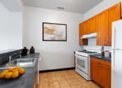 Thumbnail 3 of 59 - A kitchen with a white stove and a tray of oranges on the counter.
