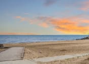 Thumbnail 39 of 45 - a sunset over the beach with a wooden dock on the beach