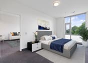 Thumbnail 13 of 59 - A bedroom with a large bed and a view of the outdoors through a window.