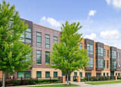 Thumbnail 22 of 59 - A modern building with a row of windows and trees in front.