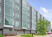 Thumbnail 21 of 59 - A modern building with grey and white exterior and large windows.