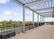 Thumbnail 16 of 59 - A long walkway with a metal railing and a roof.