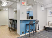 Thumbnail 23 of 39 - a bar area with stools and a kitchen in the background at Eden Commons, Chicago