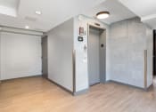 Thumbnail 25 of 39 - elevators with a wood floor and grey walls at Eden Commons, Chicago, Illinois