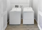 Thumbnail 16 of 45 - two washing machines in a laundry room with a wood floor