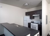 Thumbnail 25 of 59 - Park Boulevard IIB image of Kitchen with white appliances including Fridge and stove, partial view of sink, and entry way