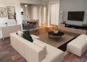 Thumbnail 1 of 17 - Cedarvale Elite One Bedroom with wood plank flooring, large layout with couch, additional seating, and artwork, with view into breakfast nook. Trendy archway architecture throughout apartment.