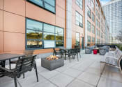 Thumbnail 7 of 45 - an outdoor patio with tables and chairs and a fire pit at Concord at Sheridan