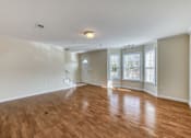 Thumbnail 7 of 9 - A room with wooden flooring and white walls.