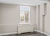 Thumbnail 13 of 19 - Bright bedroom with radiator and window blinds at Dominion Towers Apartments, Arlington, Virginia