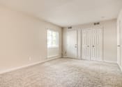 Thumbnail 20 of 23 - A room with a carpeted floor and two doors at Potomac Ridge Apartments, Woodbridge, VA, 22191
