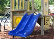 Thumbnail 22 of 23 - A blue slide is attached to a wooden play structure at Potomac Ridge Apartments, Woodbridge, 22191
