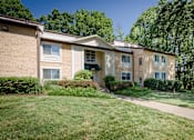 Thumbnail 7 of 23 - A building with a green lawn in front at Potomac Ridge Apartments, Woodbridge, VA
