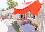 Thumbnail 4 of 33 - Outdoor patio seating area with red umbrella at Cantera Apartments, El Paso