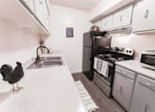 Thumbnail 25 of 33 - Modern kitchen with stainless steel appliances and white cabinets at Cantera Apartments, El Paso, Texas